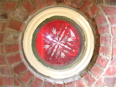 A red circle of glass within a brick wall (I`m experimenting with literalist captions now).