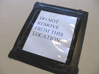 Since the sign is taped to the table, it must by definition always be in `this location.`