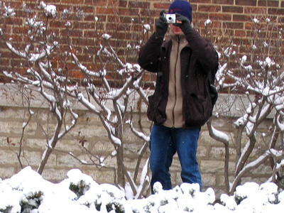 A guy outside taking pictures of the snow.  What`s HIS problem?