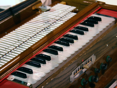 Harmonium: a portable reed organ with a small keyboard and hand-operated bellows, invented in France and introduced to India by missionaries.