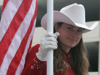 Holding a flag in one hand and a horse`s reins in another makes it hard to give the parade wave.