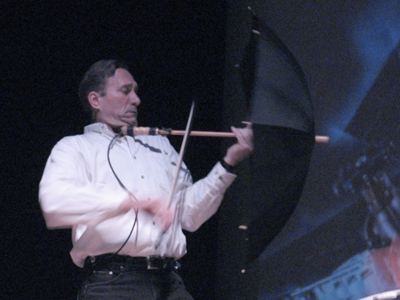 Ken Butler plays music on an umbrella.