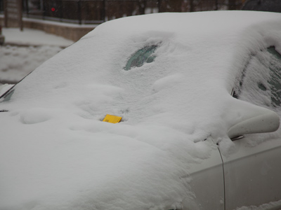 Someone from Parking Services cleared a hole in the snow to determine if the car had a permit, then left a ticket.