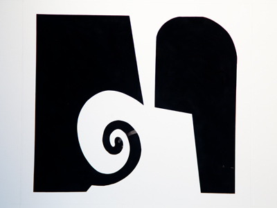 Part of another display by Los Dialoguistas.  On this white paper, the black design was created using candle smoke.  Some doubter evidently smudged it with their finger.