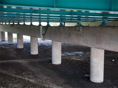 Above my head, thousands of tons of traffic moved ponderously along the interstate.