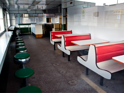 This old diner is available to a new owner.  It comes already equipped with furniture and grease on the grill.