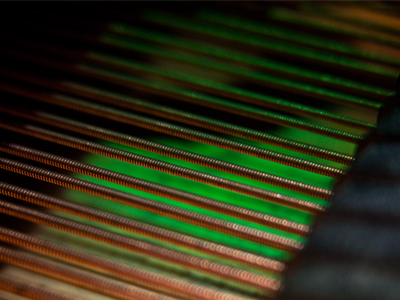 A piano sits beneath the stained glass window.