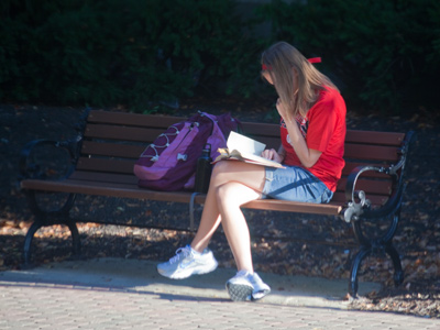 She`s reading a book.  Her cell phone must be broken.