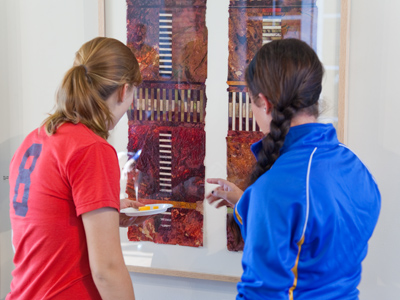 Students show their appreciation for Peter Gooch`s paintings, and for the free refreshments.