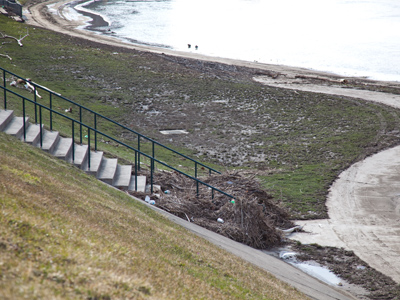 The swollen river has receded (see March 7 above), leaving behind mounds of debris and a rancid smell.