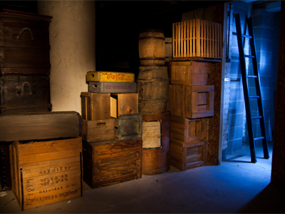 I pointed an ordinary flashlight at the boxes and barrels for about 20 seconds, and then went into the little room and fired my flash several times using a blue theatrical gel.