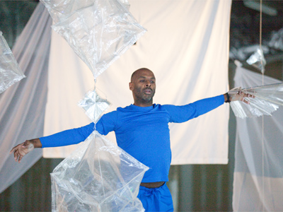 Rodney Veal dances among hanging metallic sculptures, using a magnetic glove to get them to dance around him.