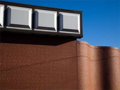 Love the square modules, curved brick wall and blue sky.  Hate the shadow of a wire.