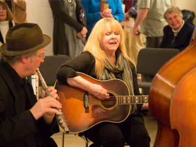 She started singing `Pastures of Plenty` and everyone in the room kept talking.