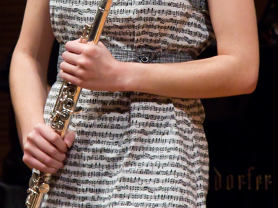 The flute player wore a dress with musical notes on it.