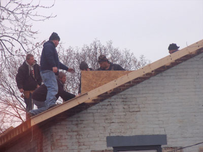 During all the warm weather months, nobody worked on the building across the street.  Now today it gets a roof.