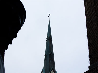 Standing on the sidewalk among garbage cans.