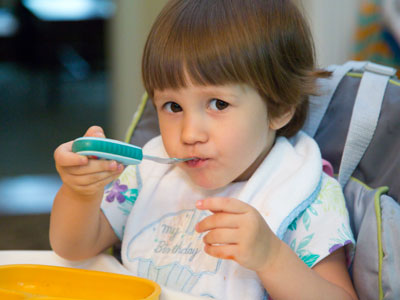 Her daddy makes some delicious hot dogs.