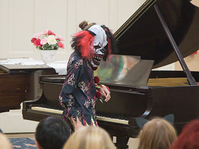 This scary clown played piano with her mask on.