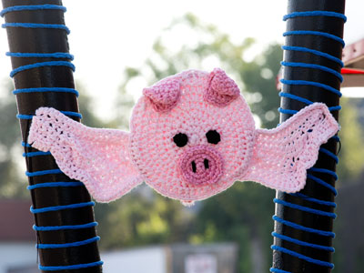 A pig with angel wings outside a barbeque restaurant.