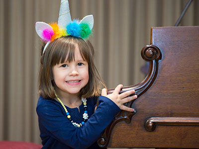 The Unicorn Princess entertains at the piano.