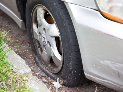 Three of this car`s four tires were flat.
