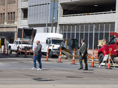 Two construction projects on opposite corners mean pedestrians have to take their chances in the street.